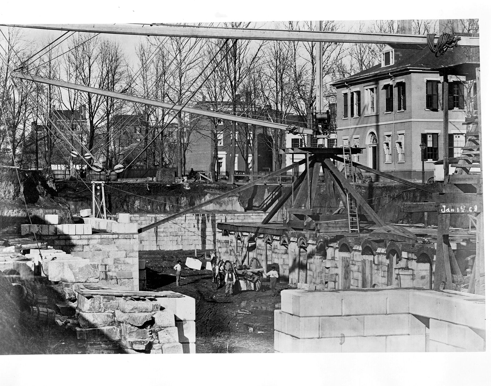 The Treasury Building under construction in 1858, with stone blocks and a wooden derrick